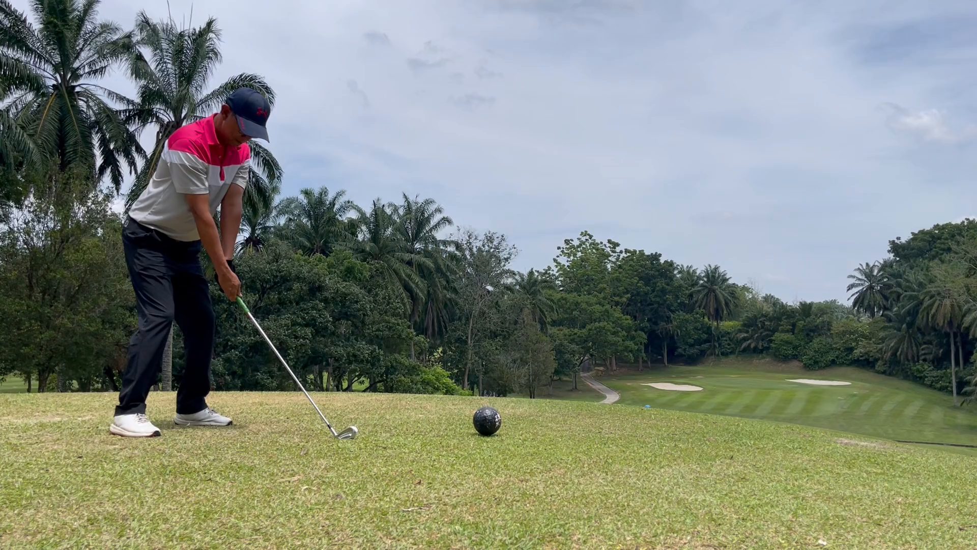 Golfer teeing off with a wide fairway ahead